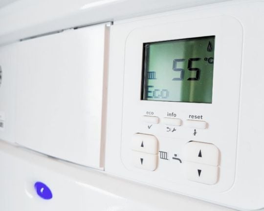 A boiler control panel highlighting the reset button to show how to reset a boiler.