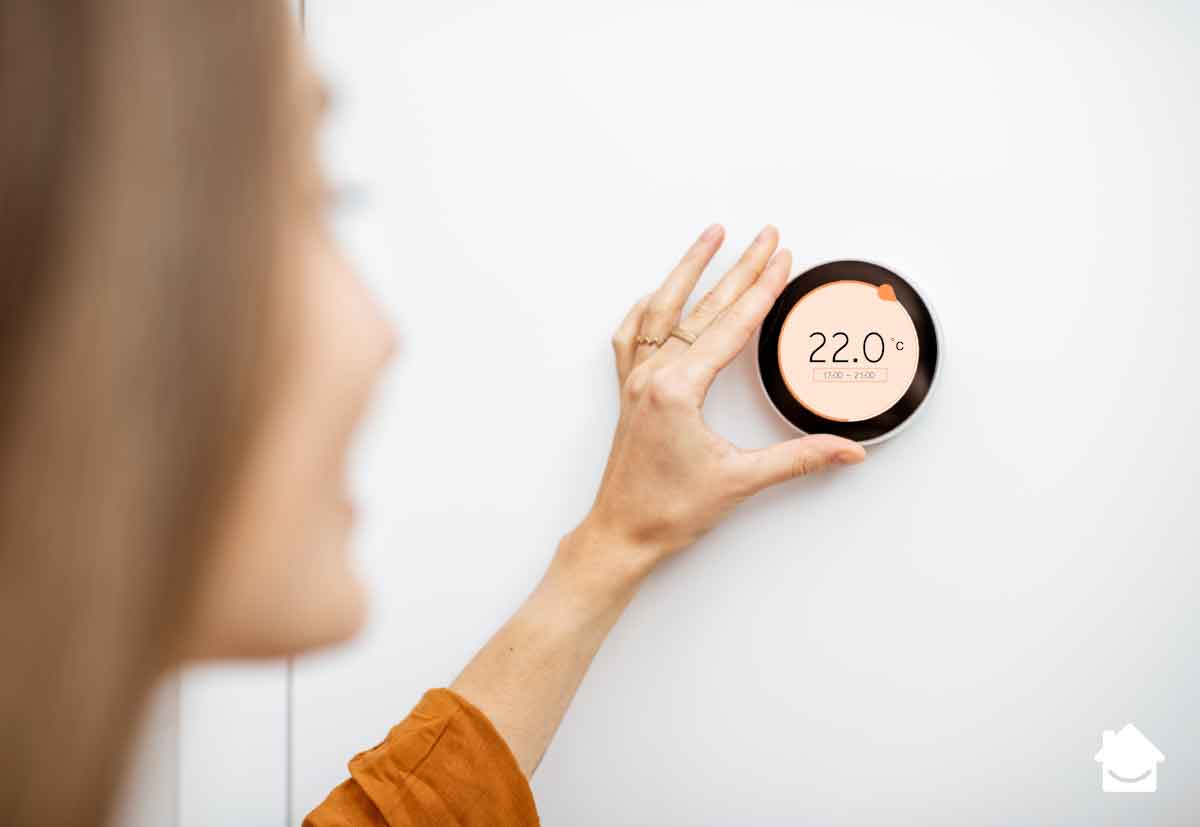 Things to check before turning the heating back on - Woman turning up thermostat