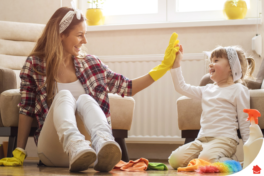 Mother and daughter high fiving while cleaning cleaning - 5 ways to prepare your home for spring