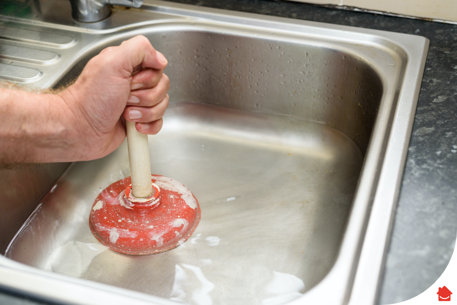 person using a plunger to clear a blocked sink - How to clear a pipe blockage