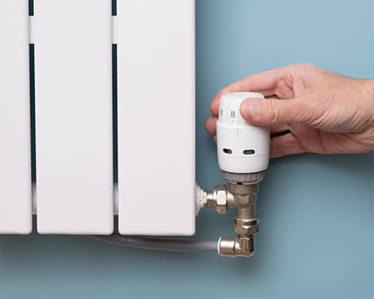 Image of a person turning the settings on a thermostatic radiator valve