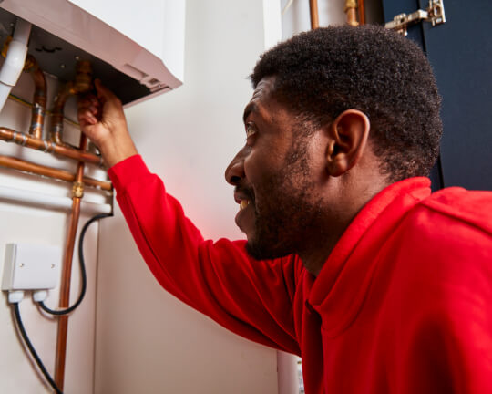 A boiler in the bedroom being serviced by a HomeServe engineer