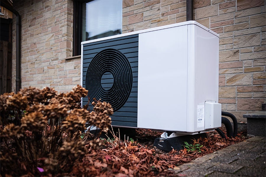 An air source heat pump in front of a house. 