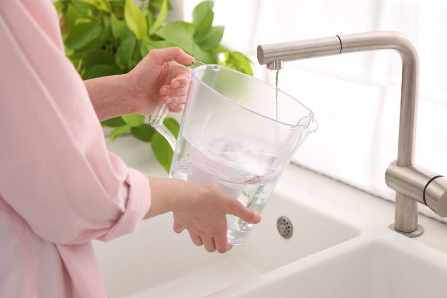 A person measuring their flow rate using a 1 litre jug