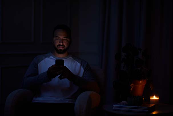 Man sitting in the dark after being ghosted by a tradesperson after an electrical fault